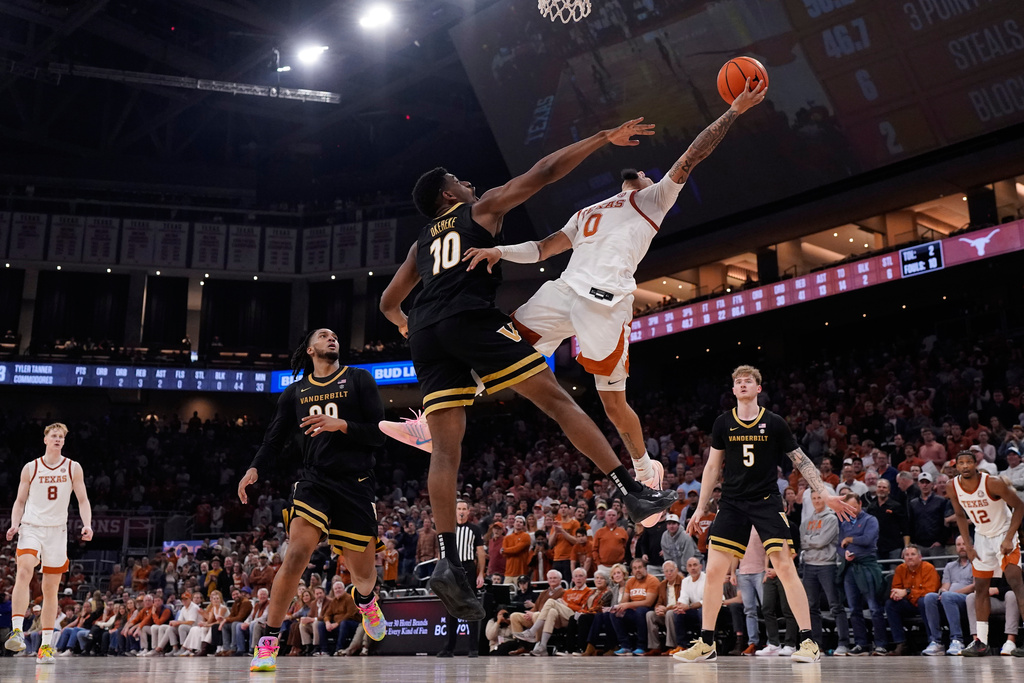 Texas guard Jordan Pope (0) drives to the basket against Vanderbilt forward Ak Okereke (10) during the second half of an NCAA college basketball game in Austin, Texas, Wednesday, Jan. 14, 2026. (AP Photo/Eric Gay)