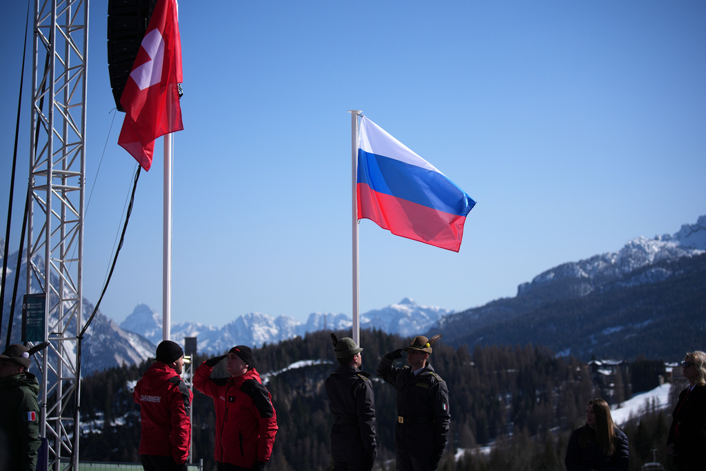 The Russian flag is hoisted during the medal ceremony for the alpine skiing men's downhill standing competition in which Aleksei Bugaev, of Russia, won the bronze medal, at the 2026 Winter Paralympics, in Cortina d'Ampezzo, Italy, Saturday, March 7, 2026. (AP Photo/Emilio Morenatti)