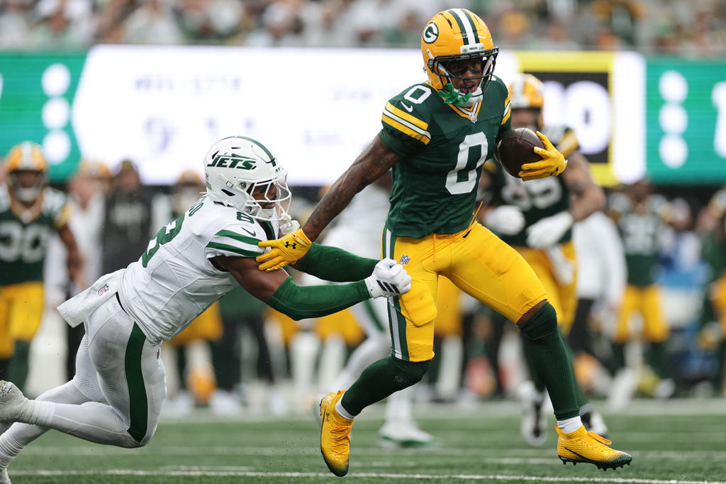 Green Bay Packers wide receiver Matthew Golden (0) runs the ball as New York Jets safety Andre Cisco (8) defends during an NFL football game in East Rutherford, N.J., Sunday, Sept. 20, 2026. (AP Photo/Adam Hunger)