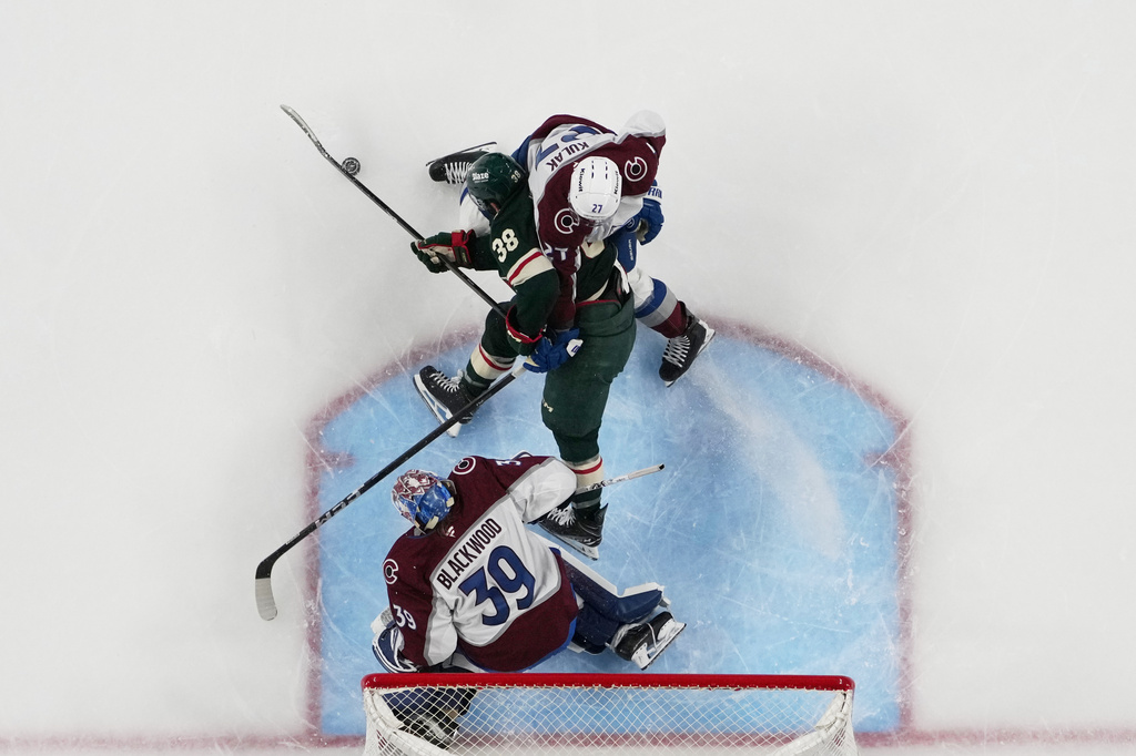 Minnesota Wild right wing Ryan Hartman (38) tries to gain control of the puck as Colorado Avalanche defenseman Brett Kulak (27) and goaltender MacKenzie Blackwood (39) defend during the third period of Game 3 of an NHL Stanley Cup hockey second-round playoff series Saturday, May 9, 2026, in St. Paul, Minn. (AP Photo/Abbie Parr)