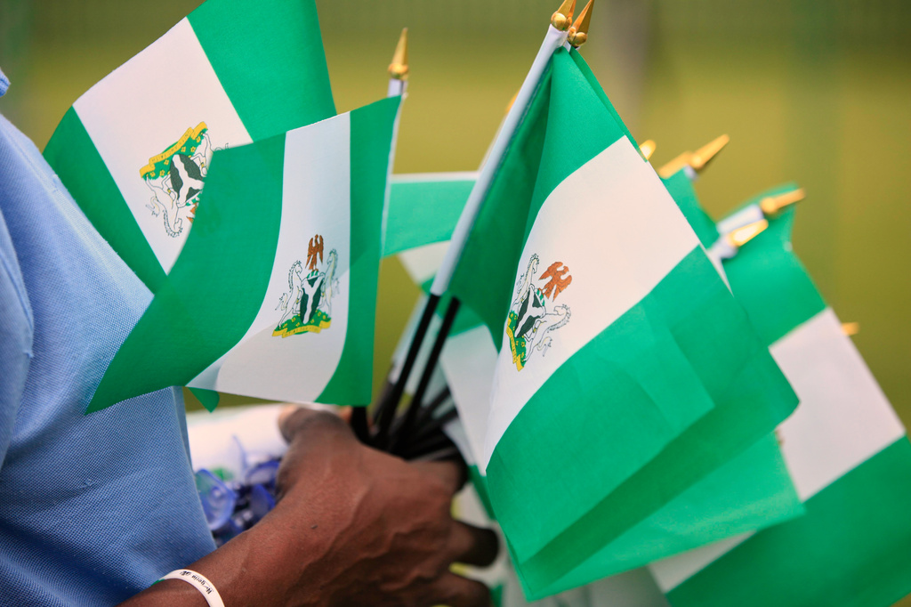 FILE - An unidentified woman sells Nigerian national flags during an event to mark Nigeria independence day in Lagos, Nigeria, Oct. 1, 2013. (AP Photo/Sunday Alamba, File)