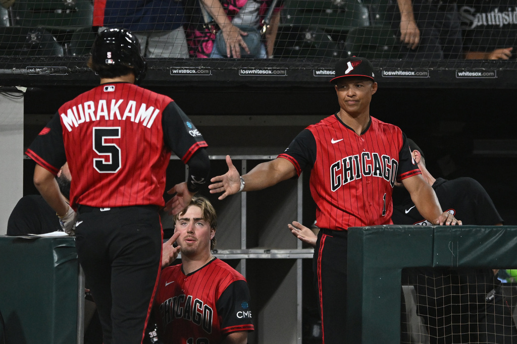 Chicago White Sox's Munnetaka Murakami (5) celebrates with manager Will Venable, right, at the dugout after scoring on a Miguel Vargus double during the seventh inning of a baseball game against The Athletics in Chicago, Friday, July 10, 2026. (AP Photo/Paul Beaty)