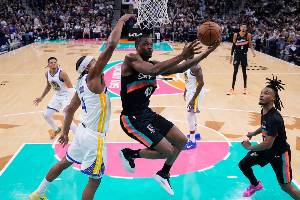 San Antonio Spurs forward Harrison Barnes (40) drives to the basket past Golden State Warriors guard Moses Moody (4) during the second half of an NBA basketball game in San Antonio, Wednesday, Nov. 12, 2025. (AP Photo/Eric Gay)