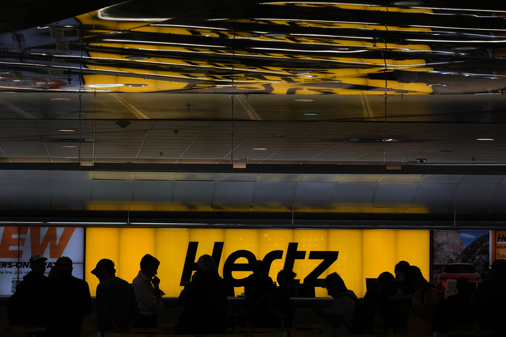 People wait in a long line at a car rental counter at Miami International Airport, Monday, Nov. 10, 2025, in Miami. (AP Photo/Rebecca Blackwell)