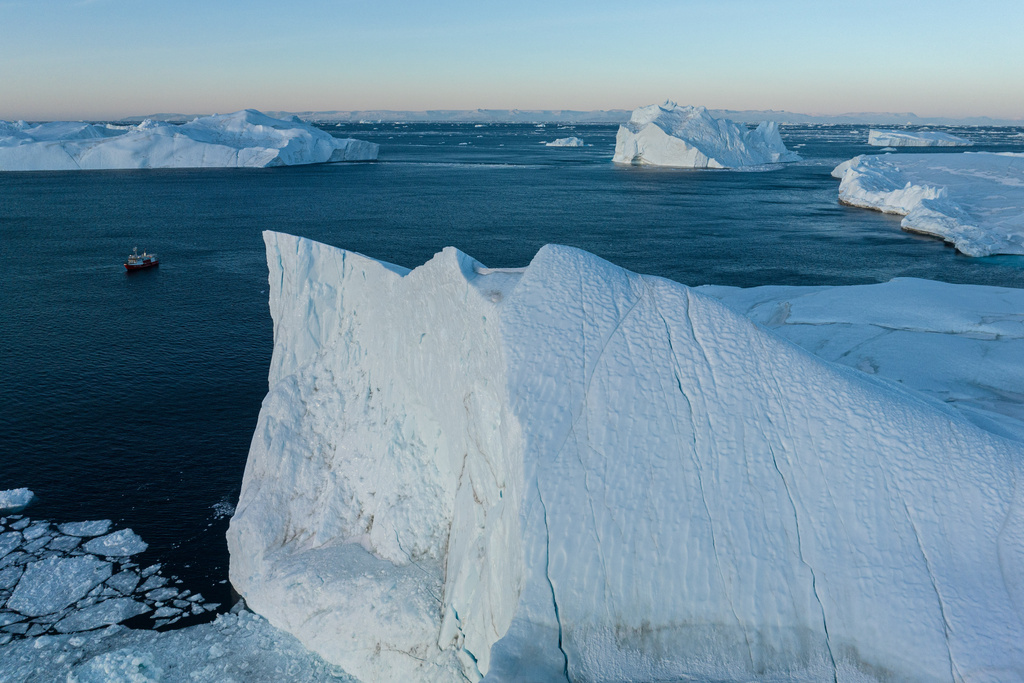 A fishing boat pulls a net up with fish in front of an iceberg at Disko Bay near Ilulissat, Greenland, on Thursday, Jan. 29, 2026. (AP Photo/Evgeniy Maloletka)