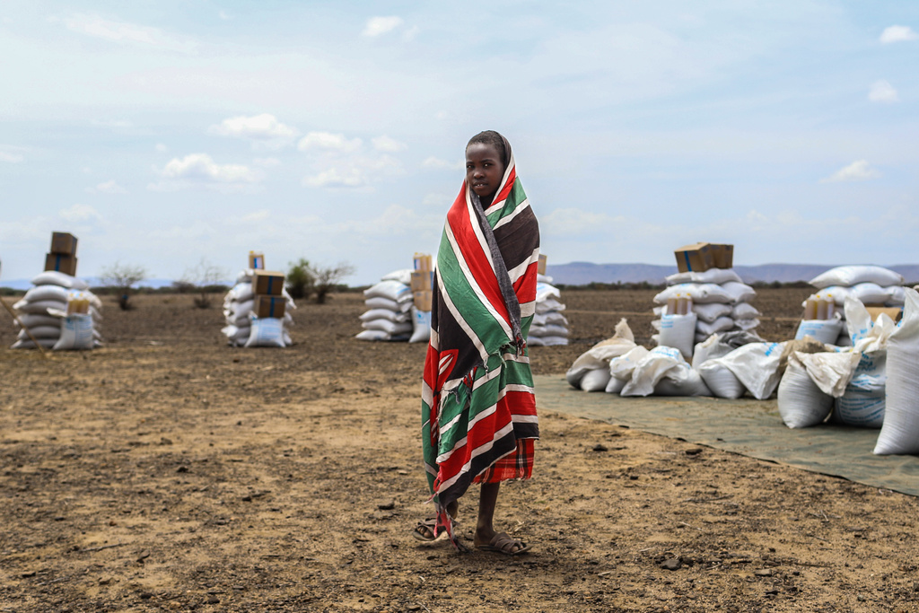 A child stands in front of food aid supplied by the World Food Programme (WFP) ahead of distribution in Nalemkais Village, Turkana County, Kenya, Sunday, Feb. 8, 2026. (AP Photo/Patrick Ngugi)