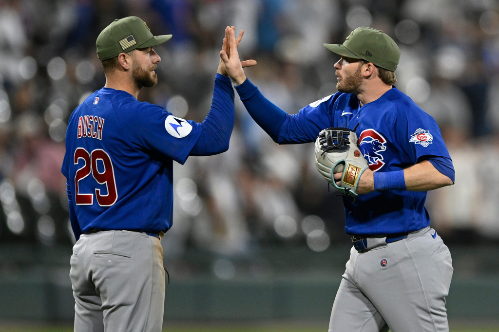 Chicago Cubs' Ian Happ, right, celebrates with teammate Michael Busch, left, after their team defeated the Chicago White Sox in a baseball game in Chicago, Friday, May 15, 2026. (AP Photo/Paul Beaty)