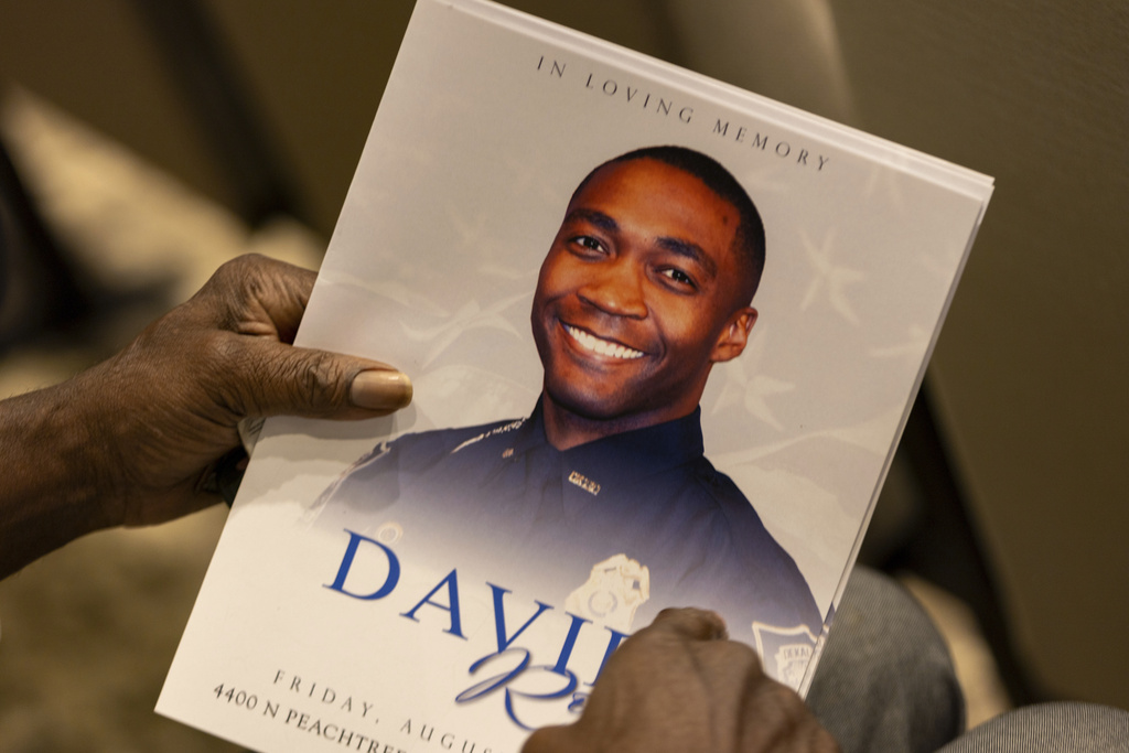 An attendee holds a program for the funeral of DeKalb County Police Officer David Rose, who was killed while responding to a shooting at the CDC, at First Baptist Church Atlanta, Friday, Aug. 22, 2025, in Atlanta. (Arvin Temkar/Atlanta Journal-Constitution via AP)