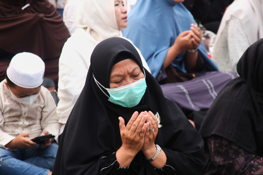 A woman prays during a prayer requesting for rain following wildfires that burn through peatlands in several regions in Sumatra and Kalimantan Island, in Palembang, South Sumatra, Indonesia, Tuesday, Aug. 25, 2026. (AP Photo/Muhammad Fajri)