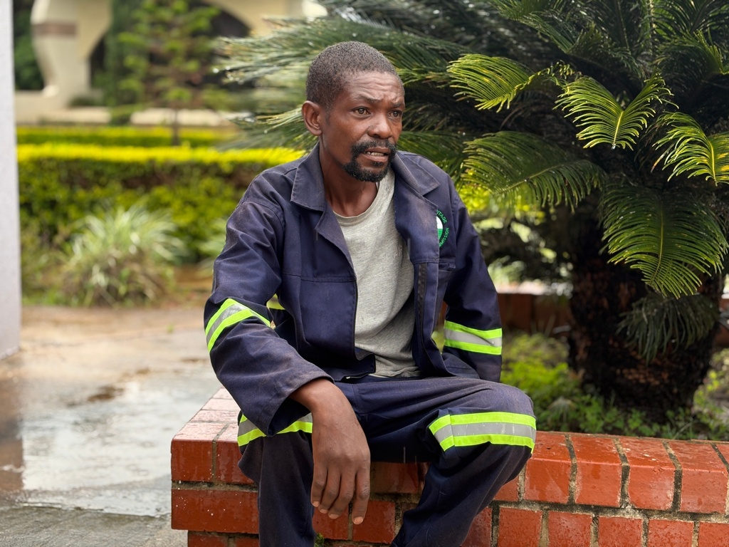 Allen Banda, cemetery caretaker, sits near the spot where authorities want to bury former president Edgar Lungu, in Lusaka, Zambia, Thursday, Feb.12, 2026. (AP Photo/Rodney Muhumuza)