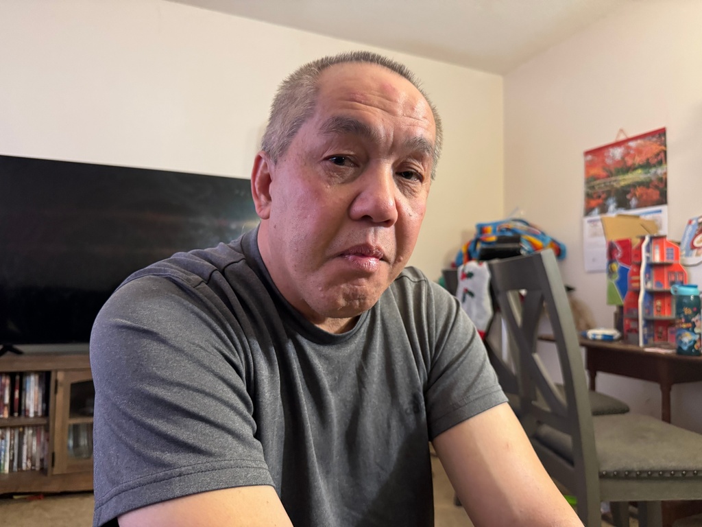 Chongly "Scott" Thao, a U.S. citizen, sits for a photo at his home Monday, Jan. 19, 2026, in St. Paul, Minn., the day after federal agents broke open his door and detained him without a warrant. (AP Photo/Jack Brook)