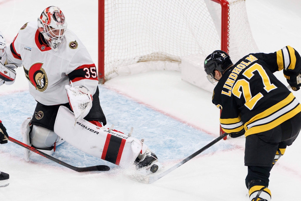Ottawa Senators goaltender Linus Ullmark (35) blocks the shot by Boston Bruins' Hampus Lindholm (27) during the first period of an NHL hockey game in Boston, Sunday, Dec. 21, 2025. (AP Photo/CJ Gunther)