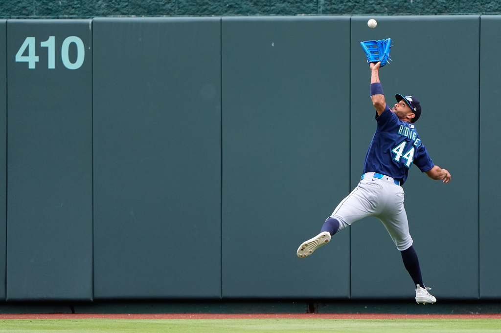Seattle Mariners center fielder Julio Rodriguez catches a fly ball for the out on Kansas City Royals' Bobby Witt Jr. during the fifth inning of a baseball game Saturday, May 23, 2026, in Kansas City, Mo. (AP Photo/Charlie Riedel)