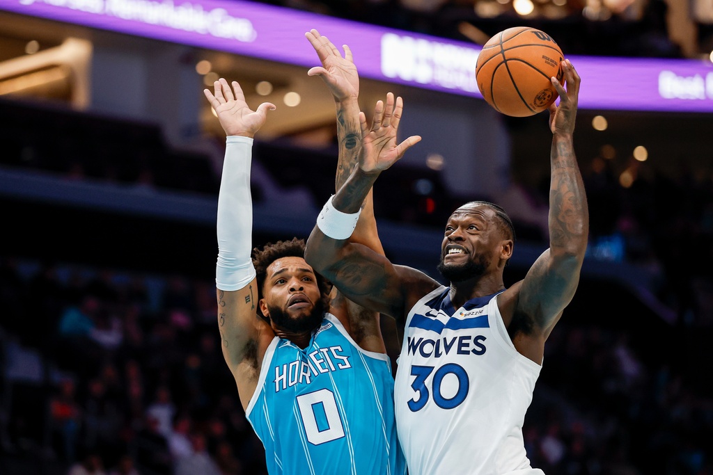 Minnesota Timberwolves forward Julius Randle (30) shoots against Charlotte Hornets forward Miles Bridges during the first half of an NBA basketball game in Charlotte, N.C., Saturday, Nov. 1, 2025. (AP Photo/Nell Redmond)