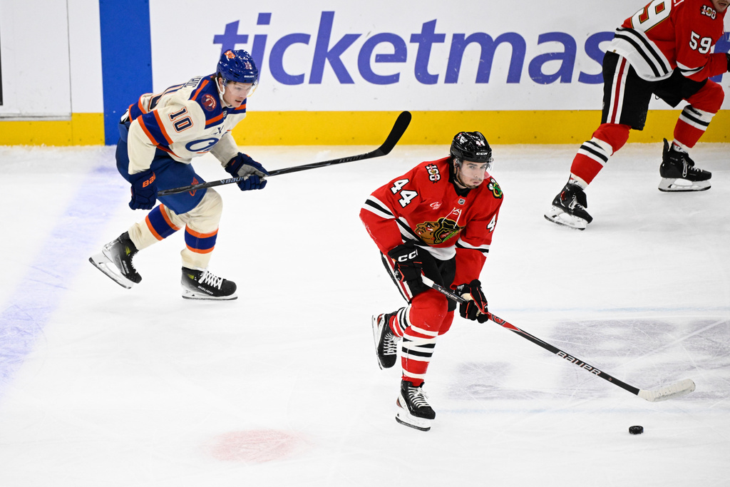 Chicago Blackhawks defenseman Wyatt Kaiser (44) moves the puck against Edmonton Oilers center Trent Frederic (10) during the second period of an NHL hockey game, Monday, Jan. 12, 2026, in Chicago. (AP Photo/Matt Marton)