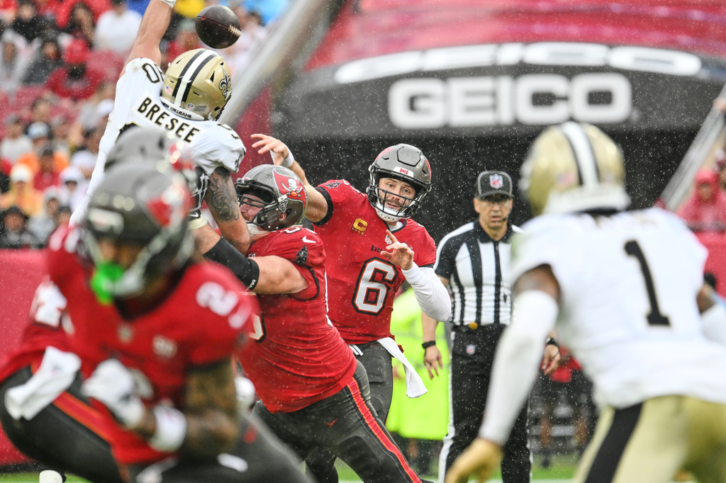 Tampa Bay Buccaneers quarterback Baker Mayfield (6) passes under pressure from New Orleans Saints defensive tackle Bryan Bresee (90) in the first half of an NFL football game, Sunday, Dec. 7, 2025, in Tampa, Fla. (AP Photo/Jason Behnken)