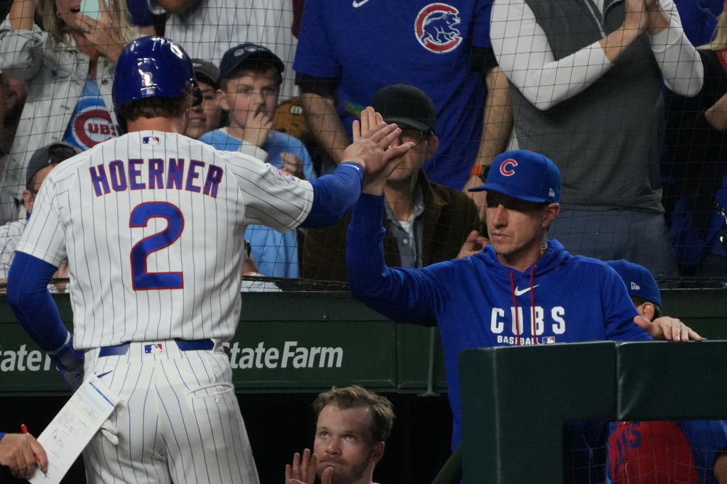 Chicago Cubs' Nico Hoerner (2) is greeted at the dugout after scoring against the Los Angeles Angels during the third inning of a baseball game Monday, March 30, 2026, in Chicago. (AP Photo/David Banks)