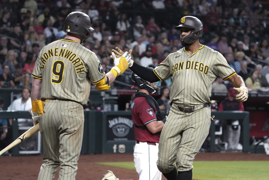 San Diego Padres' Xander Bogaerts celebrates with Jake Cronenworth (9) after hitting a solo home run against the Arizona Diamondbacks in the seventh inning during a baseball game, Wednesday, Aug 6, 2025, in Phoenix. (AP Photo/Rick Scuteri)