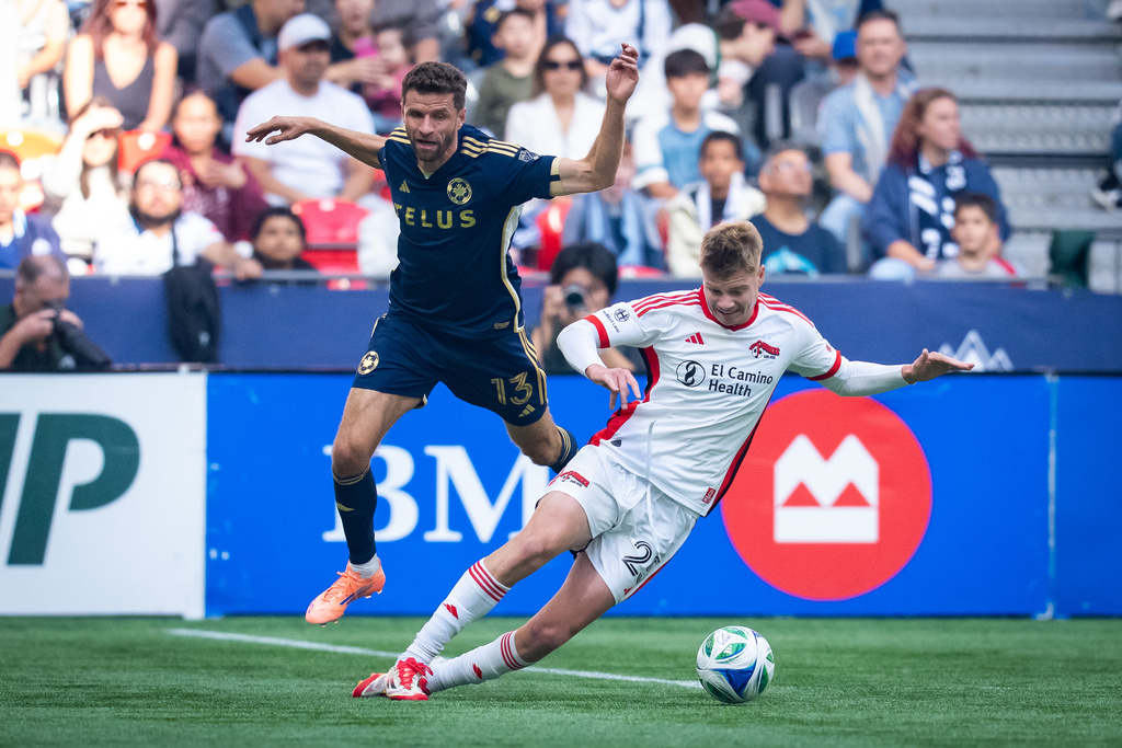 Vancouver Whitecaps' Thomas Muller (13) collides with San Jose Earthquakes' Max Floriani, right, during the first half of an MLS soccer match in Vancouver, British Columbia, Sunday, Oct. 5, 2025. (Ethan Cairns/The Canadian Press via AP)
