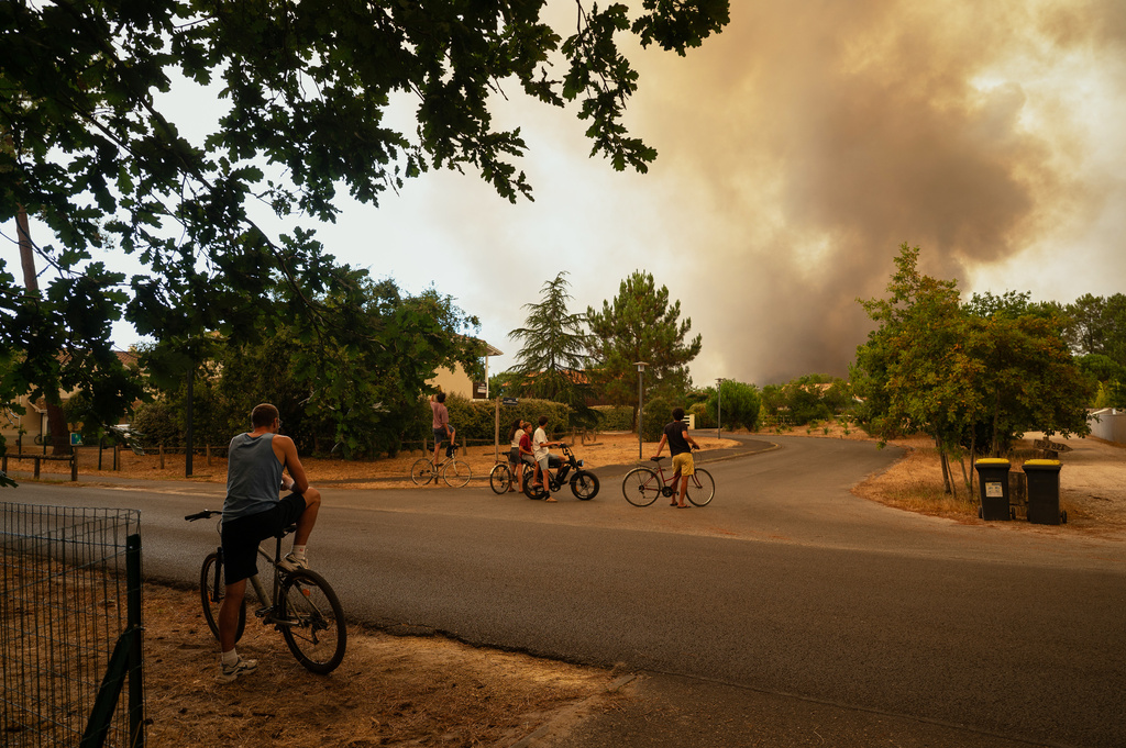 FILE - People watch a pyrocumulonimbus, a giant cloud created by a large wildfires in Le Porge, western France, Thursday, July 23, 2026. (AP Photo/Caroline Blumberg, File)