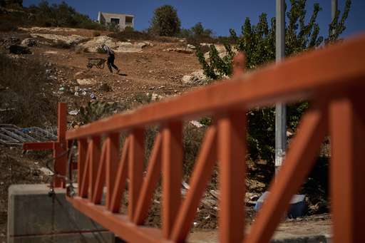 A Palestinian man pushes a wheelbarrow past a closed gate set up by Israeli authorities that blocks an entrance to the West Bank village of Sinjil, Tuesday, Sept. 30, 2025. (AP Photo/Leo Correa) A Palestinian man pushes a wheelbarrow past a closed gate set up by Israeli authorities that blocks an entrance to the West Bank village of Sinjil, Tuesday, Sept. 30, 2025. (AP Photo/Leo Correa)
