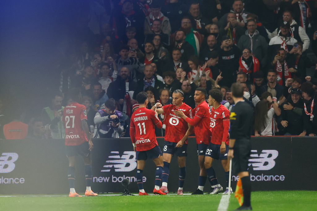 Lille's Ethan Mbappe, centre, celebrates with teammates after scoring his side's opening goal during the French League One soccer match between Lille and Paris Saint-Germain at the Stade Pierre-Mauroy in Villeneuve-d'Ascq, outside Lille, France, Sunday, Oct. 5, 2025. (AP Photo/Jean-Francois Badias)