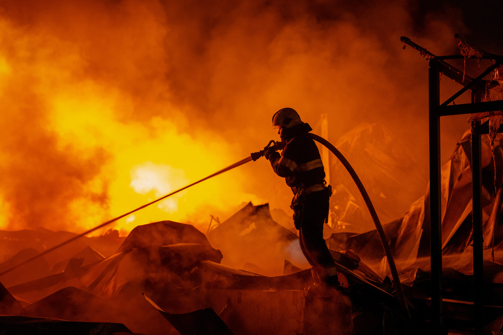 Firefighters put out a fire after Russian missiles hit a warehouse in Kyiv, Ukraine, Wednesday, Aug. 5, 2026. (AP Photo/Dan Bashakov)