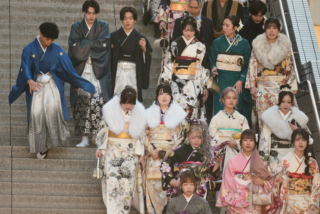 Young adults arrive at a venue to celebrate the Coming-of-Age Day, a centuries-old tradition and national holiday marking the milestone from childhood to adulthood, Monday, Jan. 12, 2026, in Yokohama near Tokyo. (AP Photo/Eugene Hoshiko)
