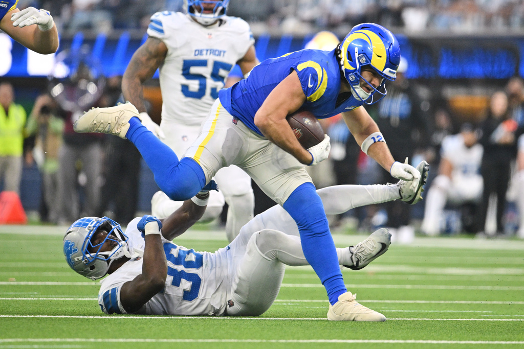 Los Angeles Rams wide receiver Puka Nacua (12) runs over Detroit Lions safety Erick Hallett (36) after a catch during the second half of an NFL football game against the Detroit Lions, Sunday, Dec. 14, 2025, in Inglewood, Calif. (AP Photo/Katie Chin)