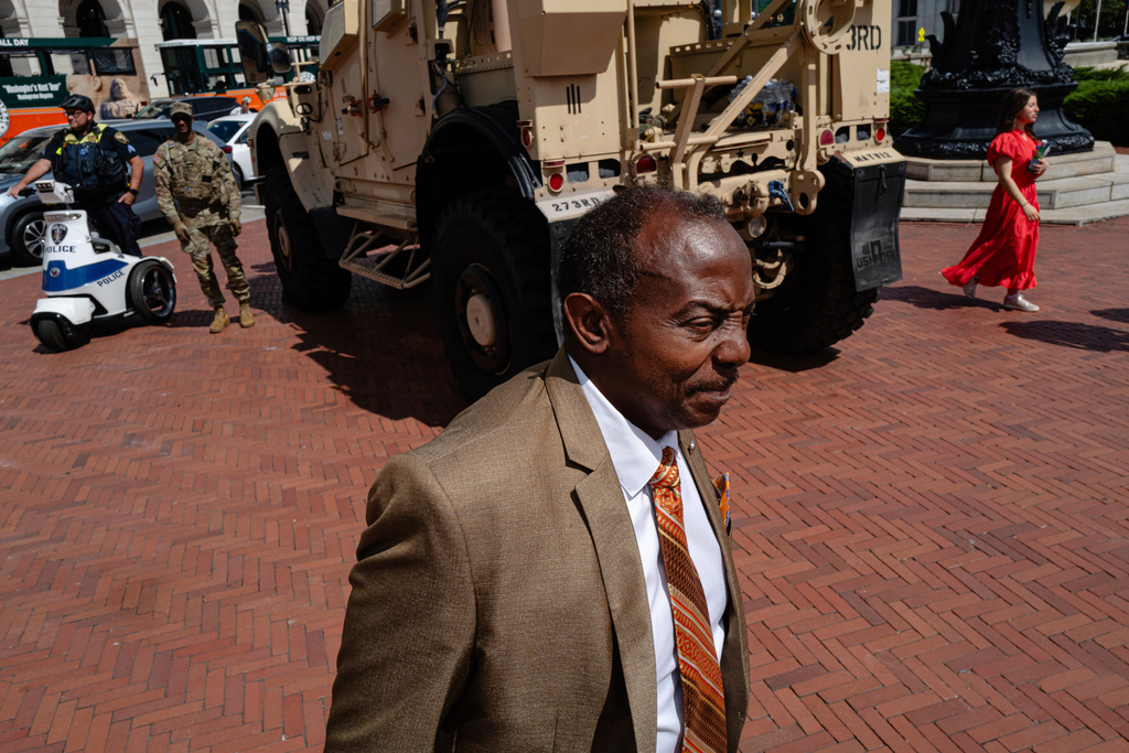 Bernard Oliver gestures while standing near a National Guard Mine Resistant Ambush Protected vehicle (MRAP) outside of Union Station, Sunday, Aug. 31, 2025, in Washington. (AP Photo/Jon Cherry)