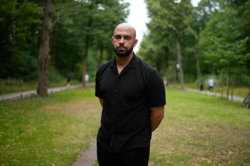 Police officer Ali Darwich poses for a portrait near the scene where a car rammed into a crowd at the Pride March in Berlin, Germany, Sunday, July 26, 2026. (AP Photo/Markus Schreiber)