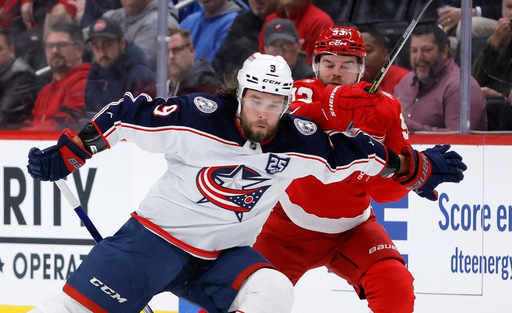 Columbus Blue Jackets defenseman Ivan Provorov (9) tries to hold off Detroit Red Wings right wing Alex Debrincat (93) during the first period of an NHL hockey game Saturday, Nov. 22, 2025, in Detroit. (AP Photo/Duane Burleson)