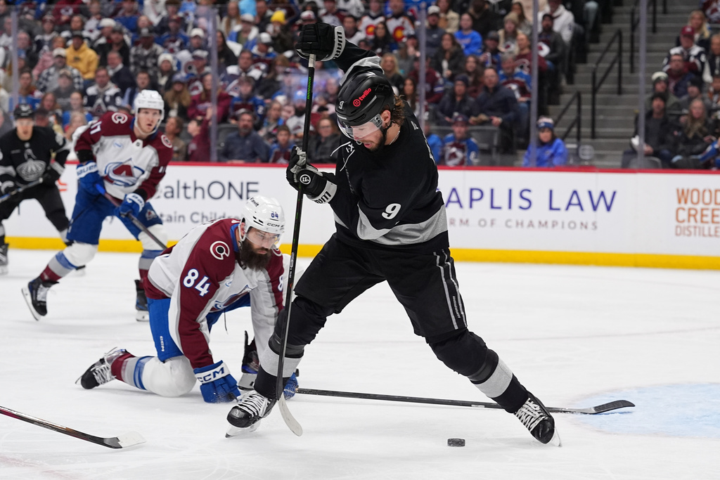 Los Angeles Kings right wing Adrian Kempe, front, redirects the puck as Colorado Avalanche defenseman Brent Burns covers in the second period of an NHL hockey game Monday, Dec. 29, 2025, in Denver. (AP Photo/David Zalubowski)