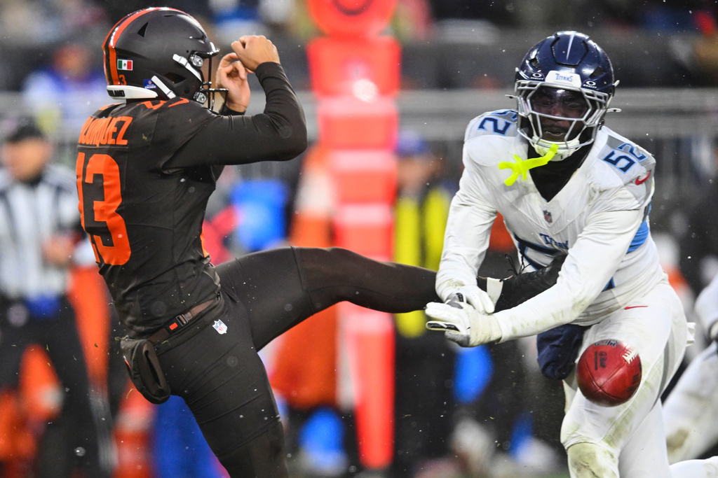 Tennessee Titans linebacker James Williams Sr. (52) blocks a punt attempt by Cleveland Browns' Corey Bojorquez (13) in the second half of an NFL football game in Cleveland, Sunday, Dec. 7, 2025. (AP Photo/David Richard)