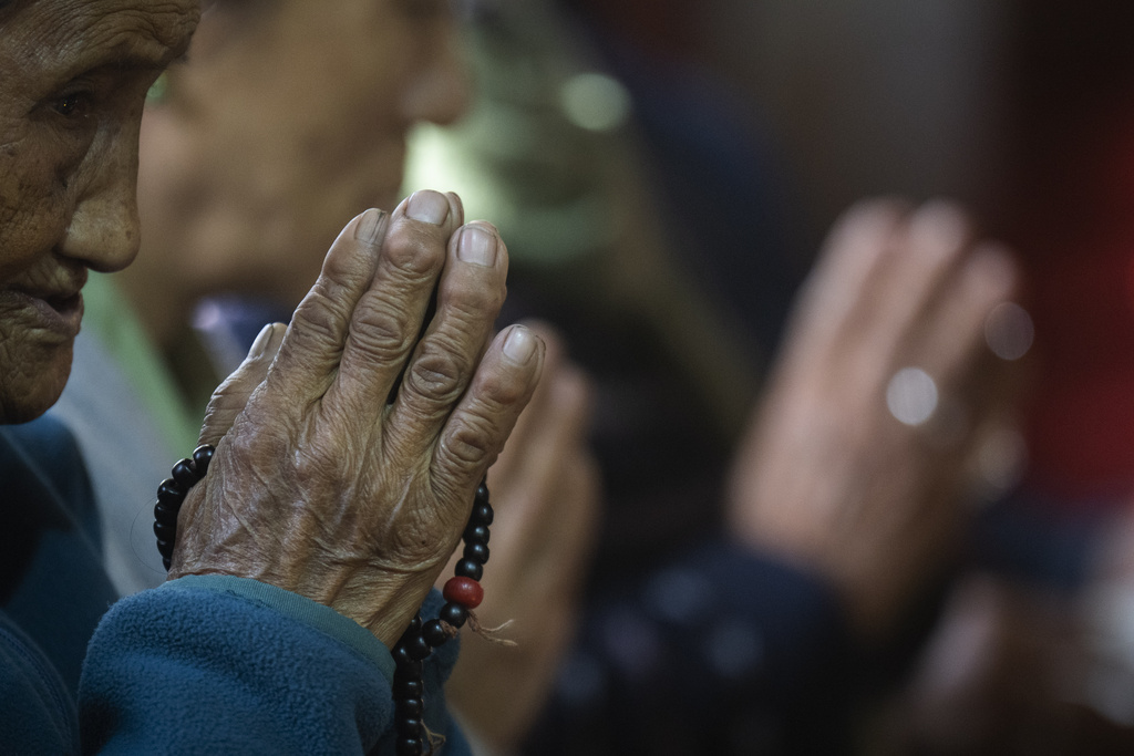 A Tibetan woman offers a prayer in the remembrance of those who lost their lives in the recent earthquake, at a Tibetan camp in Lalitpur, Nepal, on Wednesday, Jan. 8, 2025. (AP Photo/Niranjan Shrestha)