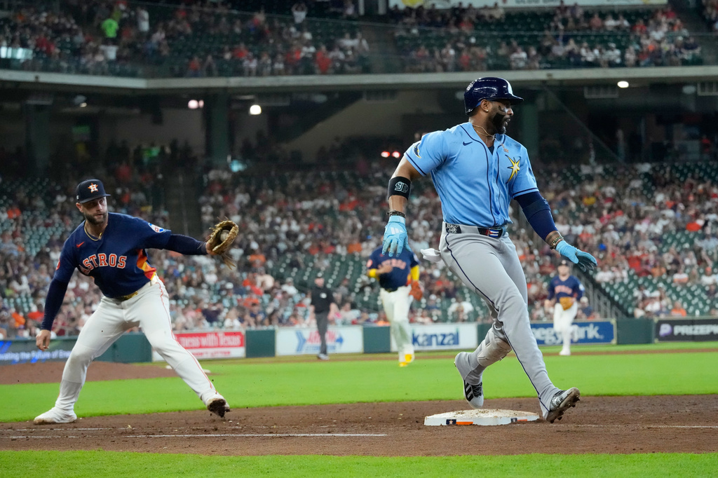 Tampa Bay Rays' Yandy Díaz, right, is safe at first base after Houston Astros first baseman Christian Walker missed the tag during the eighth inning of a baseball game Sunday, July 5, 2026, in Houston. (AP Photo/David J. Phillip)