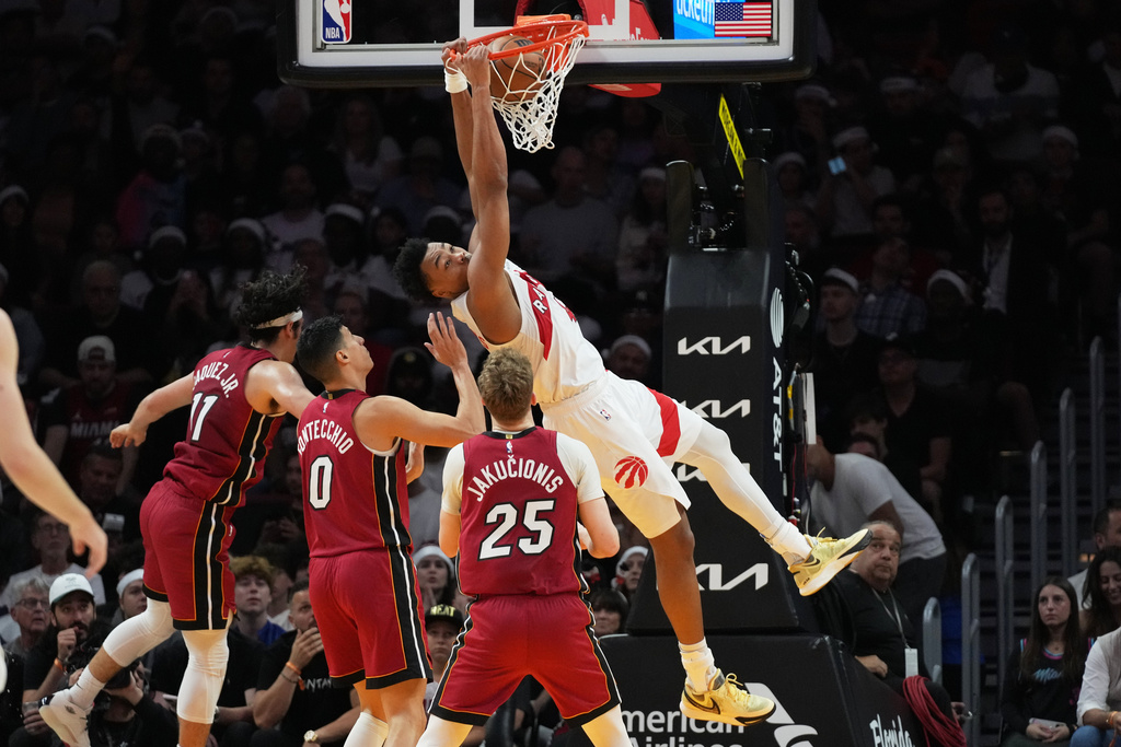 Toronto Raptors forward Scottie Barnes, right, dunks during the first half of an NBA basketball game against the Miami Heat, Tuesday, Dec. 23, 2025, in Miami. (AP Photo/Lynne Sladky)