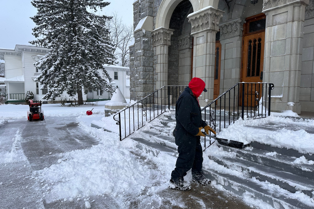 A man shovels snow outside a church in Lowville, N.Y., on Friday, Nov. 28, 2025. (AP Photo/Cara Anna)