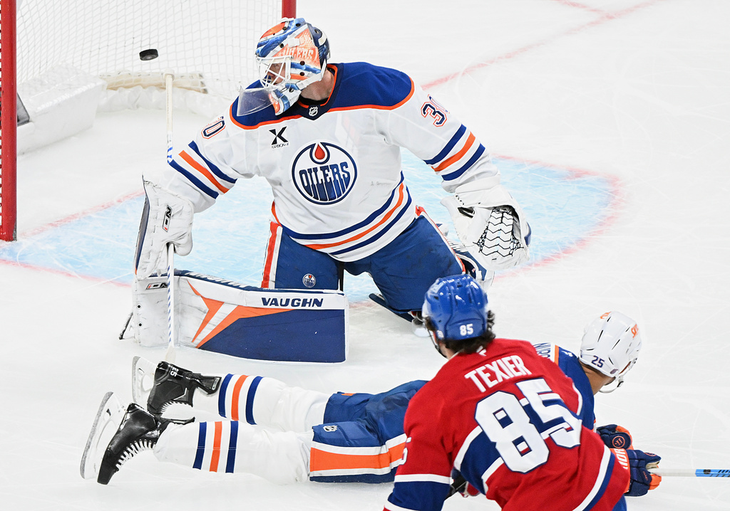 Montreal Canadiens' Alexandre Texier (85) scores against Edmonton Oilers goaltender Calvin Pickard (30) as Oilers' Darnell Nurse (25) tries to block the shot during the third period of an NHL hockey game, in Montreal, Sunday, Dec. 14, 2025. (Graham Hughes/The Canadian Press via AP)