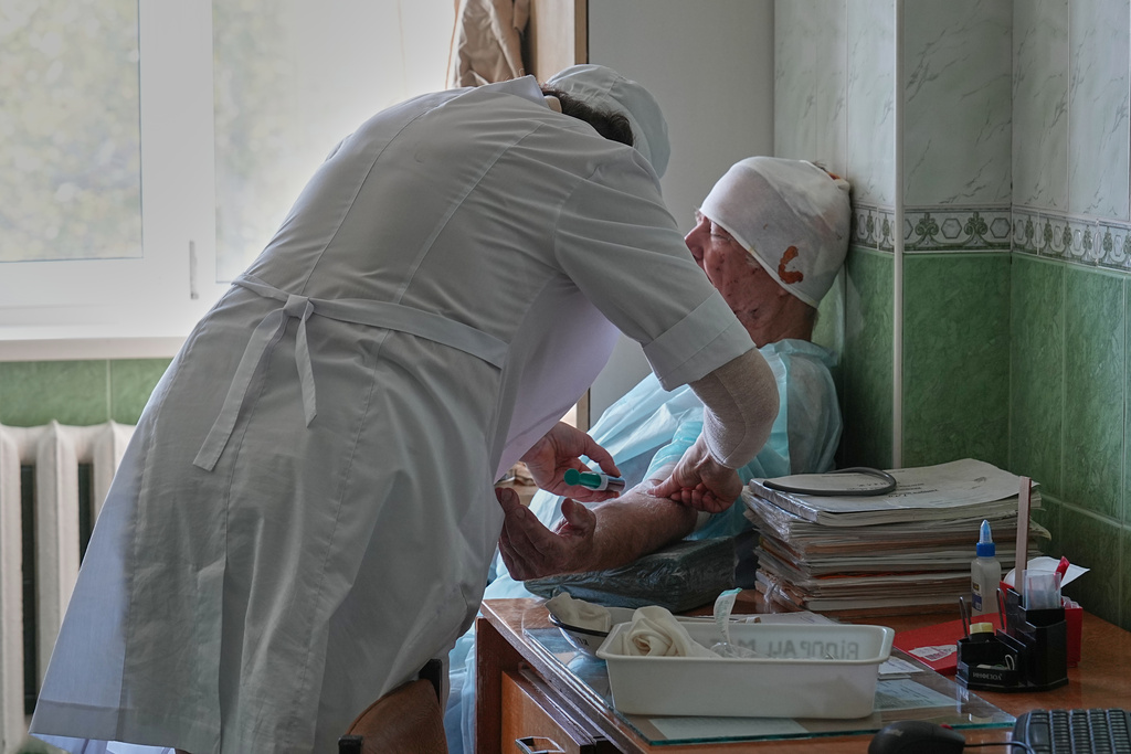 A wounded local resident gets treatment at one of the city main hospitals treating drone victims in the frontline city of Kherson, Southern Ukraine, Monday, Nov. 3, 2025. (AP Photo/Efrem Lukatsky)