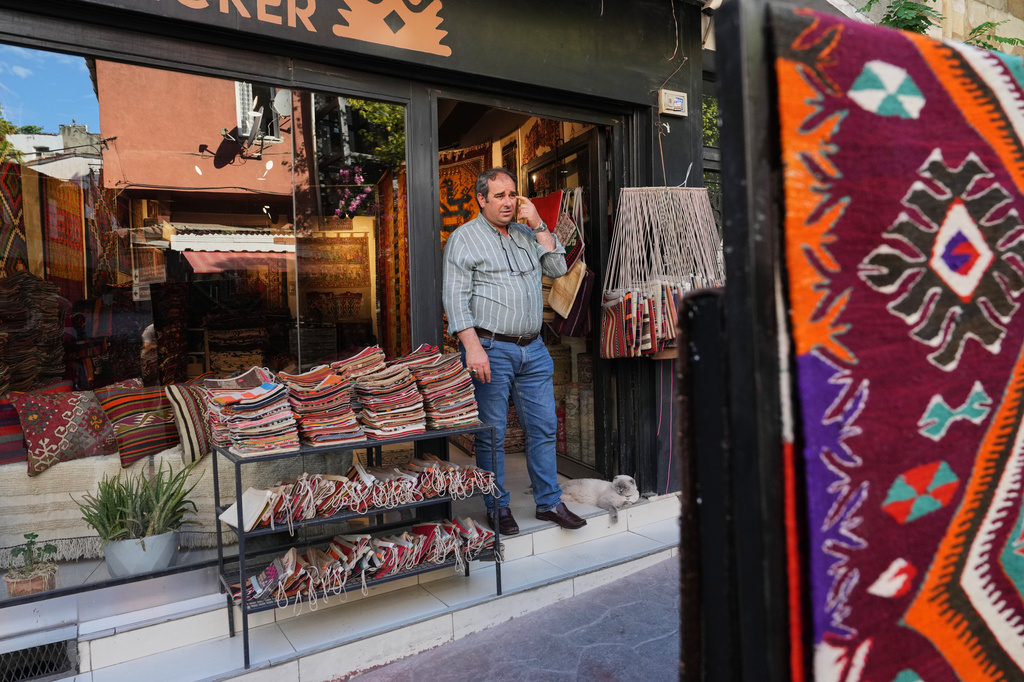 Turkish carpet merchant Ali Osman Aykul stands at the entrance of his shop as he waits for clients in Istanbul, Turkey, on Wednesday, June 17, 2026. (AP Photo/Francisco Seco)