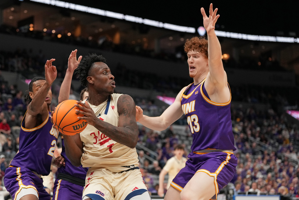 UIC's Abdul Momoh, left, looks to pass round Northern Iowa's Will Hornseth during the first half of the championship game in the Missouri Valley Conference NCAA college basketball tournament Sunday, March 8, 2026, in St. Louis. (AP Photo/Jeff Roberson)