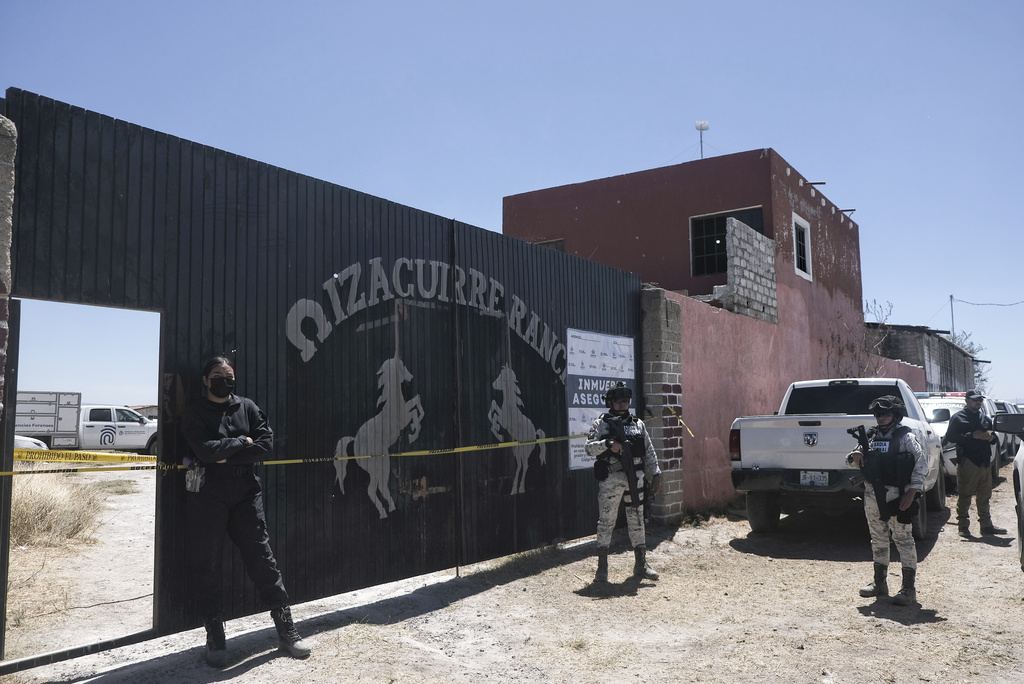 FILE - Police stand guard outside the entrance of the Izaguirre Ranch where skeletal remains were discovered in Teuchitlan, Jalisco state, Mexico, March 13, 2025. (AP Photo/Alejandra Leyva, File)