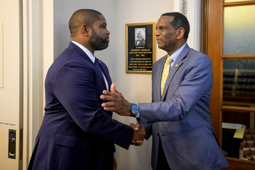 Rep. Byron Donalds, R-Fla., left, shakes hands with Rep. Burgess Owens, R-Utah, right, prior to a formal dedication of the House Press Gallery in honor of Frederick Douglass on Capitol Hill, Thursday, Feb., 12, 2026, in Washington. Frederick Douglass was the first African American reporter admitted into the Capitol press galleries. (AP Photo/Rod Lamkey, Jr.)