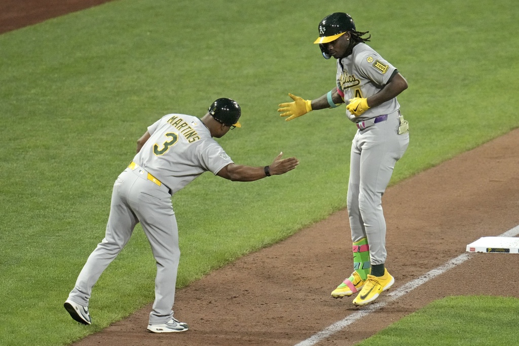Athletics' Lawrence Butler, right, is greeted by third base coach Eric Martins (3) as he rounds third after hitting a three-run home run off Pittsburgh Pirates pitcher Mitch Keller during the fifth inning of a baseball game in Pittsburgh, Friday, Sept. 19, 2025. (AP Photo/Gene J. Puskar)