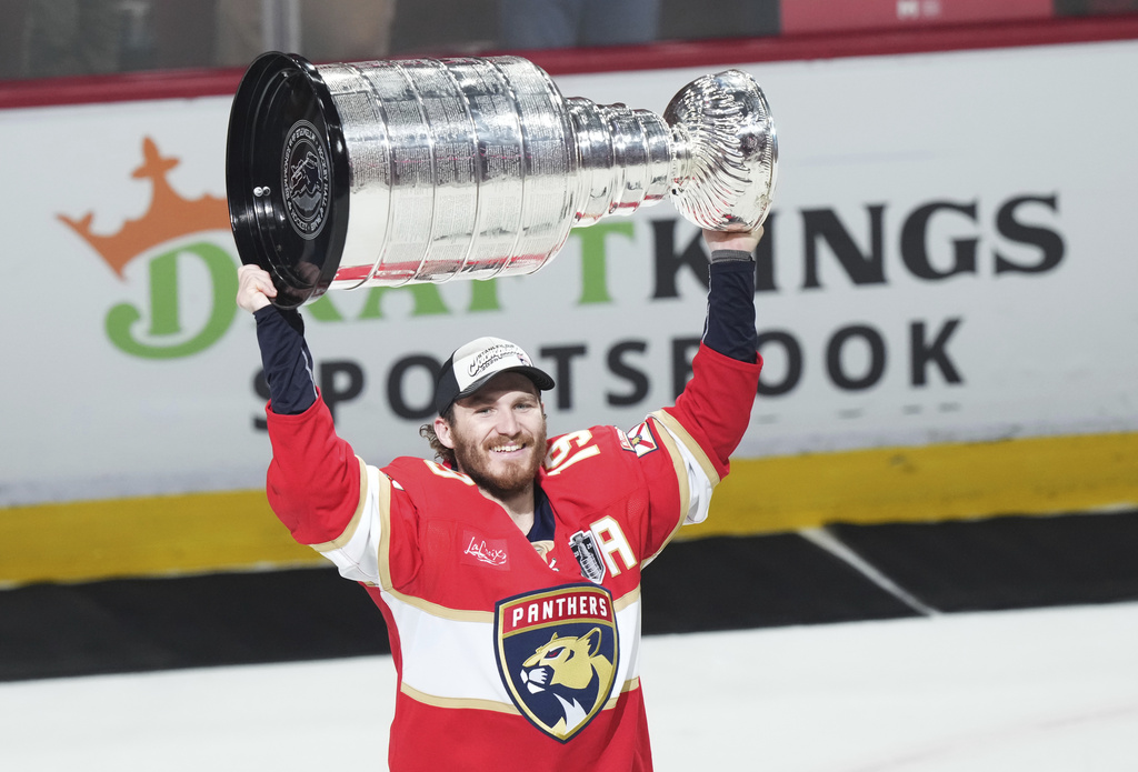 Florida Panthers' Matthew Tkachuk (19) raises the Stanley Cup after defeating the Edmonton Oilers in Game 6 of the NHL hockey Stanley Cup Final in Sunrise, Fla., Tuesday, June 17, 2025. (Nathan Denette/The Canadian Press via AP)
