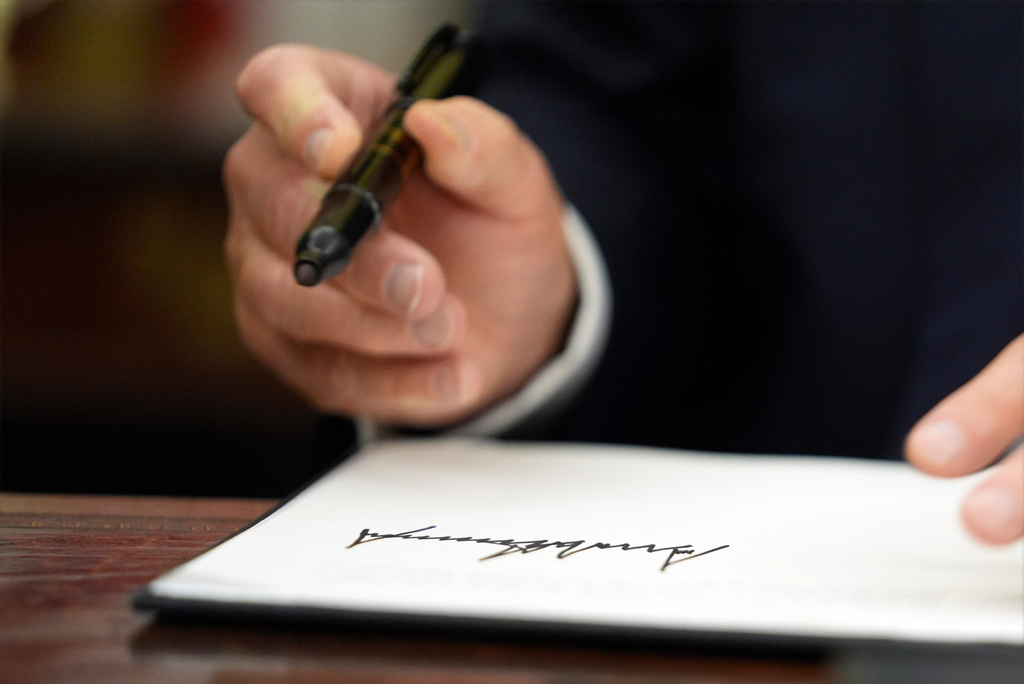 FILE - President Donald Trump signs executive orders in the Oval Office of the White House, Monday, Jan. 20, 2025, in Washington. (AP Photo/Evan Vucci, File)
