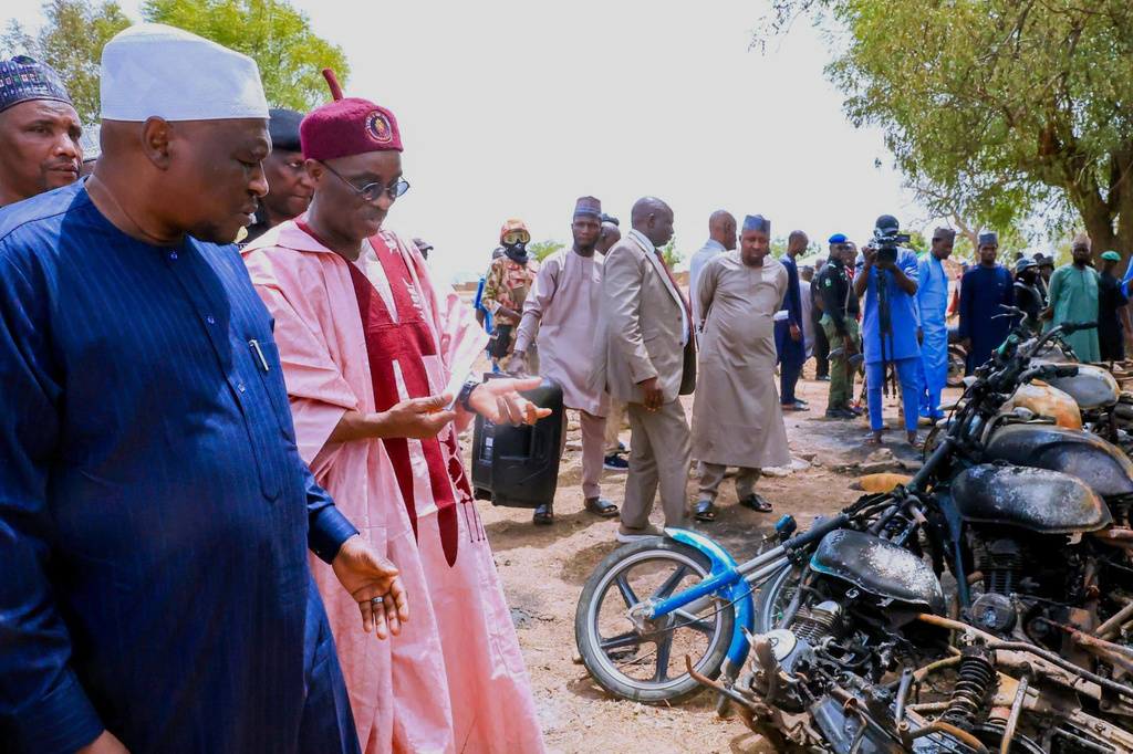 In this photo, released by Adamawa State Government House, Adamawa State Governor Ahmadu Umaru Fintiri, front left, inspects an area in Guyaku, northeastern Nigeria, Monday, April 27, 2026, that was attacked by Militants with the Islamic State group on Sunday. (Adamawa state government house via AP)