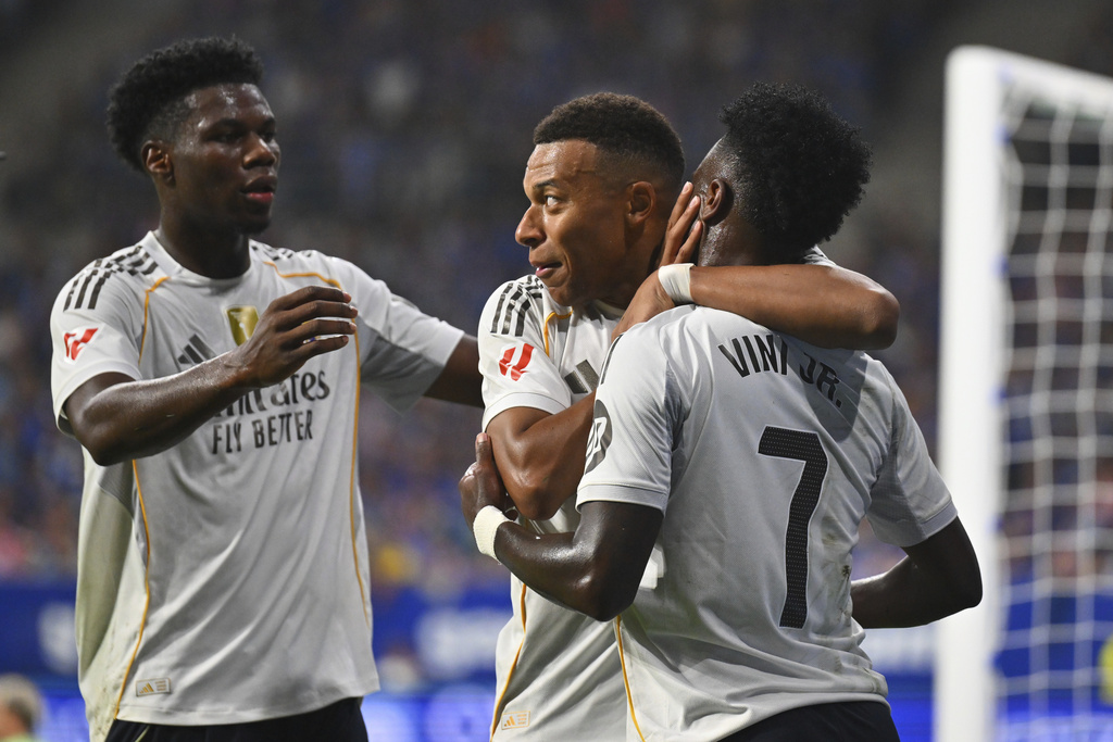 Real Madrid's Kylian Mbappe, center, is congratulated by teammates Vinicius Junior, right, and Aurelien Tchouameni after scoring his side's 2nd goal during a Spanish La Liga soccer match between Real Oviedo and Real Madrid at Carlos Tartiere stadium in Oviedo, Spain, Sunday, Aug. 24, 2025. (AP Photo/Miguel Oses)