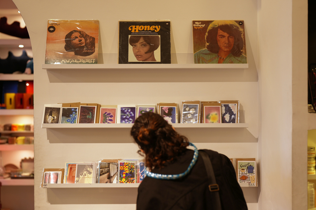 A woman browses postcards in a gift shop in central Tehran, Iran, Wednesday, April 8, 2026. (AP Photo/Francisco Seco)